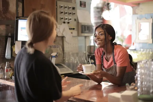 Starbucks Barista giving coffee to blonde customer