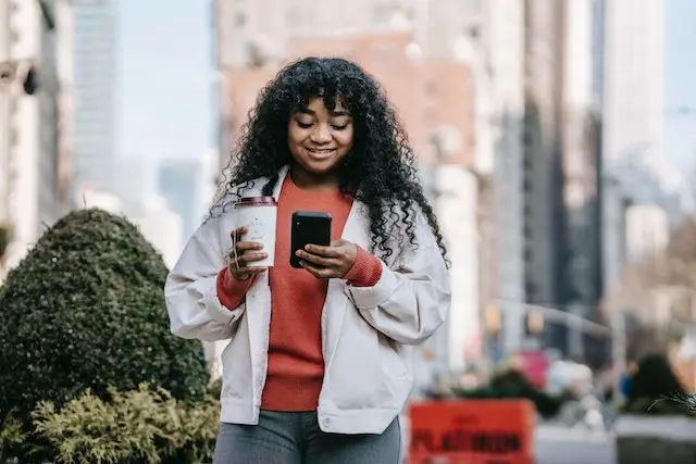 Girl smiling with phone and Starbucks coffee