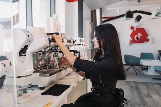 Woman in Black Jacket Making Coffee Using the Espresso Machine
